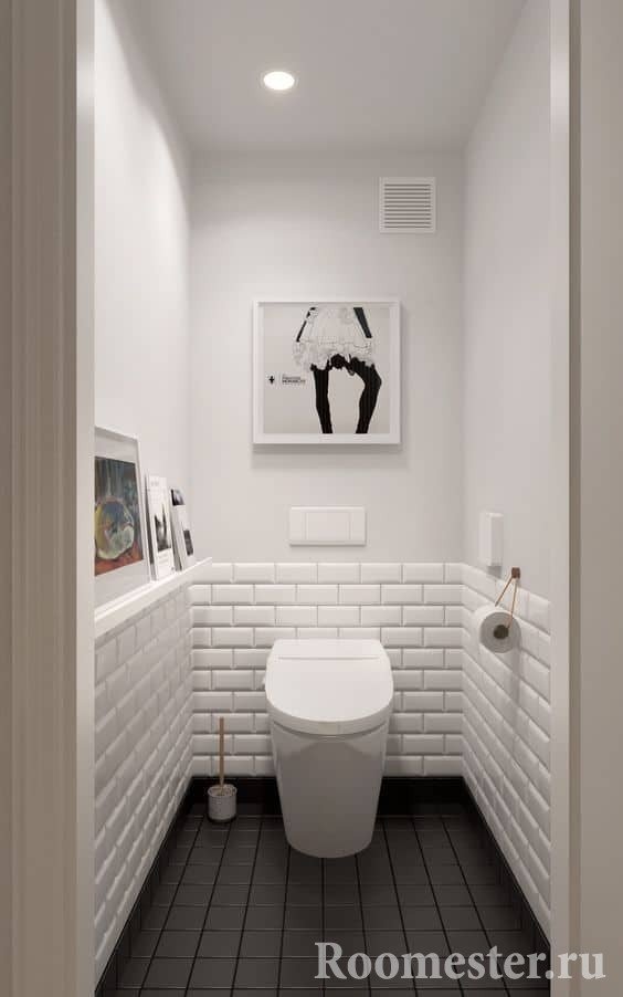 Liten toalett i vitt med mörkt golv