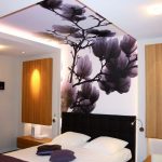 Das Design der Decke im Schlafzimmer mit Tapete mit Perspektive