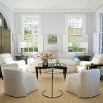 Et værelse med hvide møbler og et brunt bord