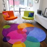 Интериор с цветни столове и килим.