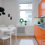 Hvidt køkken med orange møbler