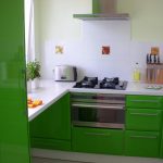 Hvite fliser og grønne møbler på kjøkkenet