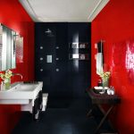 Lavabo y espejo en una pared roja