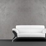 Hvit sofa mot en grå vegg