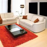 Czerwony dywan i białe sofy