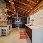Mur en pierre et plafond en bois dans la cuisine