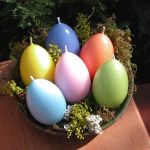 Värikkäitä kynttilöitä munien muodossa.
