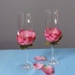 Huwelijksglazen met roze bloemblaadjedecoratie