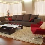 Ruskea sohva ja punainen nojatuoli olohuoneessa