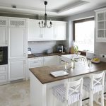Kjøkken med hvite møbler og en mørk benkeplate