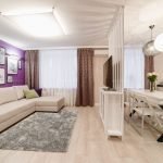 Dinding ungu dengan lukisan putih di ruang tamu