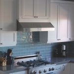 Keuken met wit meubilair en een lichtblauw schort