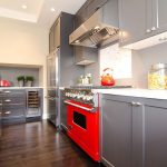 Sivi namještaj i crvena peć u kuhinji