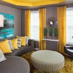 La combinación de paredes grises y cortinas amarillas en la sala de estar.