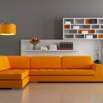 Narożna pomarańczowa sofa w szarym wnętrzu