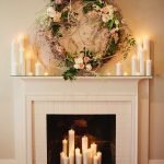 Coroa de flores e velas em uma lareira decorativa