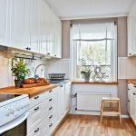 Móveis brancos com bancadas de madeira natural na cozinha