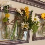 Panel med fotorammer, vaser og friske blomster