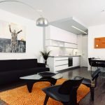 Svarte møbler og oransje teppe i stuen