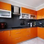 Στερεά μαύρη ποδιά σε πορτοκαλί κουζίνα