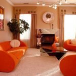 Oransje lenestoler og sofa i stuen