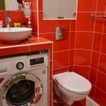 Oranžinės plytelės vonios kambaryje su skalbimo mašina