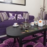 Interiér útulného obývacího pokoje ve fialovém nábytku