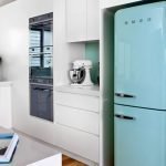 Hvite møbler og et turkis kjøleskap på kjøkkenet