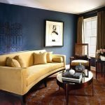 Písečná pohovka a modré stěny v obývacím pokoji