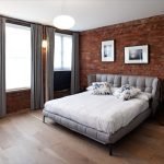 Mursteinvegg og grå gardiner på soverommet