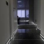 Koridor sa svijetlim zidovima i tamnim podom.