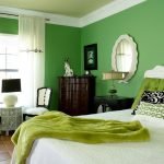 Espejo blanco en la pared verde en el dormitorio