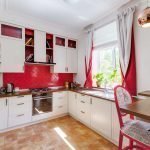 Biela kuchyňa s červenou zásterou
