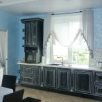 La combinación de paredes azules y muebles negros en la cocina.