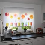 Γλάστρες με λουλούδια σε κουρτίνα στην κουζίνα