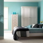 Yatak odasında turkuaz duvarlar ve beyaz mobilya kombinasyonu