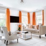 Oranžové závesy vo svetlej obývacej izbe