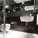 Vonios kambario dizainas yra juodas su baltomis grindimis