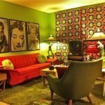 Kombinationen av ljusgröna väggar och en orange soffa