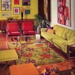 غرفة مع أريكة خضراء وكراسي حمراء