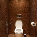 Chocolate-colored mosaic tiles in the design of the toilet