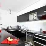The combination of red, black and white colors in the kitchen