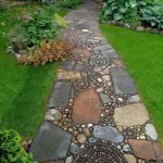 Piedras naturales grandes y pequeñas en el diseño del camino del jardín.