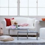 Almohadas rojas y rosadas en un sofá blanco
