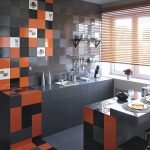 Oransje og svart i utformingen av et lite kjøkken