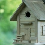 Homemade birdhouse made of boards with a decorative door