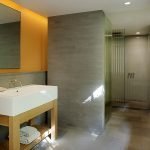 Gelbe Wand in einem grauen Badezimmer
