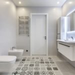 Grå fliser med etnisk mønster på badeværelse gulvet.