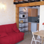 Црвени кауч у кухињи са белим зидовима