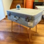 Malý stolík vyrobený zo sivého kufra